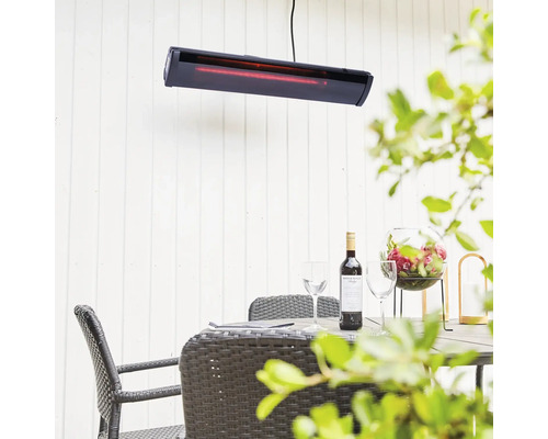 Uteplats med värmelampa, bord, stolar, vin och dekoration för en mysig atmosfär