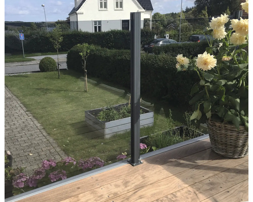 Trädgårdsscen med metallstolpar och glasstaket på träterrass