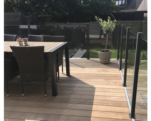 Trädäck med trägolv, trädgårdsbord och glasräcke