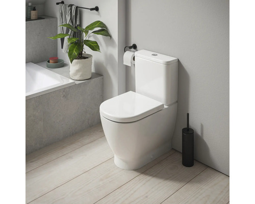 Vit toalett med cistern i ett badrum