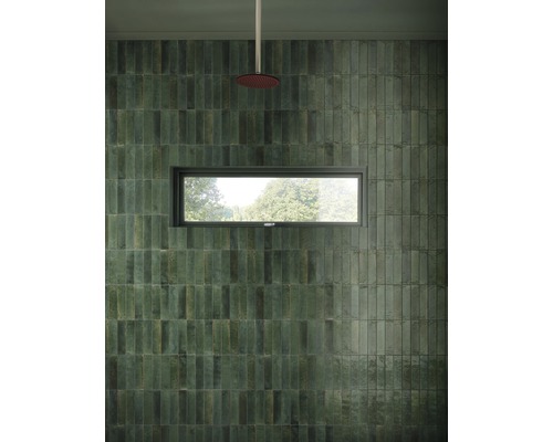 Badrum med grönt väggkakel, fönster och regndusch