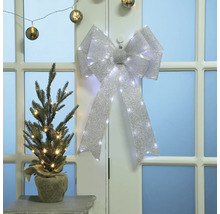 Julscen med dekorerad julgran och rosett med ljus