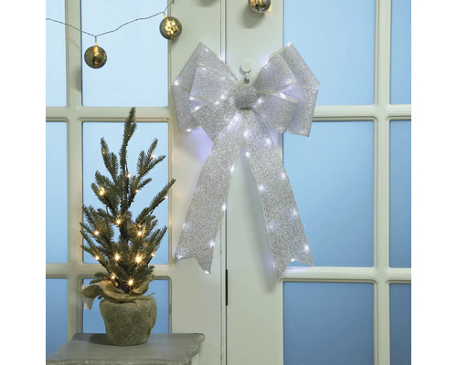 Julscen med dekorerad julgran och rosett med ljus