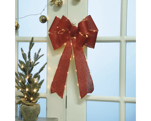 Dekorativ juldekoration med rosett och mini julgran