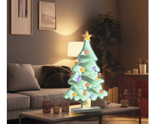 Dekorativ julgran med stjärna och kulor på bordet