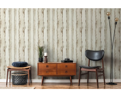 Vardagsrum med träpanelstapeter, byrå, stol och golvlampa