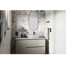 Ljust badrum med tvättställ, spegel och blommig tapet