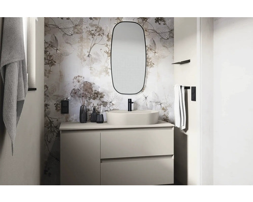 Ljust badrum med tvättställ, spegel och blommig tapet