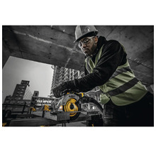 Man med skyddshjälm och skyddsglasögon använder en handhållen cirkelsåg av märket DeWalt på en byggarbetsplats