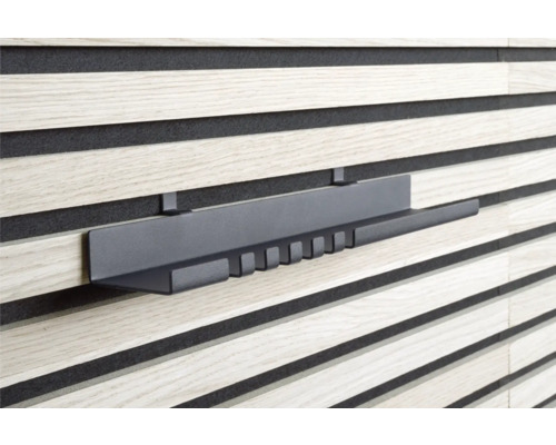 Grå hylla på en träpanelvägg