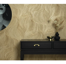 Gyllene strukturtapet i ett rum med en svart konsol