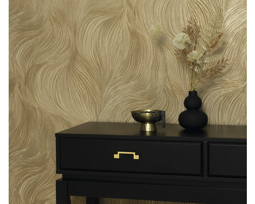 Dekorativ tapet med vågigt mönster bakom ett svart bord med en guldskål och vas