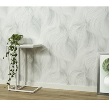 Vardagsrum med mönstrad tapet och sidobord