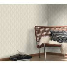 Vardagsrum med geometrisk tapet, stol och dekorativa element för en stilfull atmosfär.