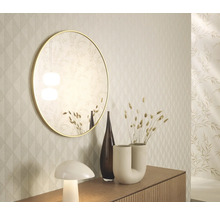 Dekorativ inredning med spegel, vaser och lampa på en skänk framför en mönstrad tapet.