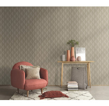 Vardagsrum med fåtölj, bord och geometrisk tapet