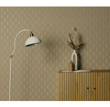 Rumsöversikt med mönstrad tapet, golvlampa och byrå med dekoration