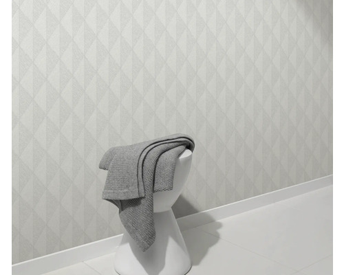 Ljus vägg med geometriskt mönster och pall med filt