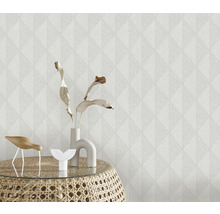 Närbild av en strukturtapet med geometriskt mönster och dekorativa föremål på ett sidobord