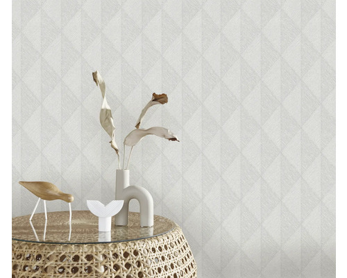 Närbild av en strukturtapet med geometriskt mönster och dekorativa föremål på ett sidobord