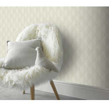 Dekorativ väggbeklädnad med geometrisk tapet bakom en stol med kuddar och dekoration