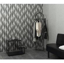 Scen med geometrisk tapet, klädhängare, bord och bänk