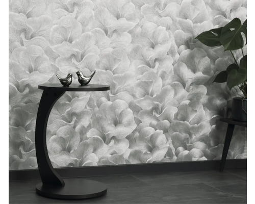 Vardagsrum med blommig tapet, sidobord och krukväxt