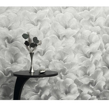 Närbild av en blommig tapet med ett litet bord och en vas