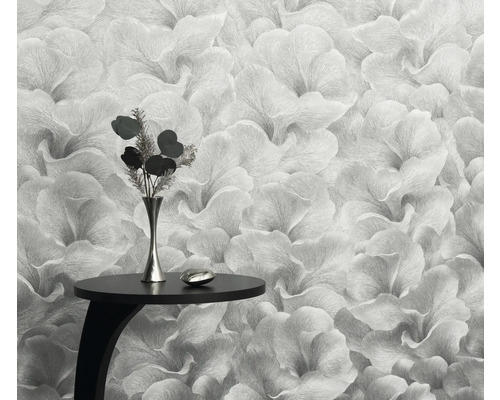 Närbild av en blommig tapet med ett litet bord och en vas