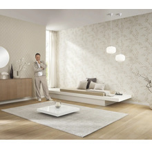 Ljust vardagsrum med mönstrade tapeter, låg soffa, matta och dekoration