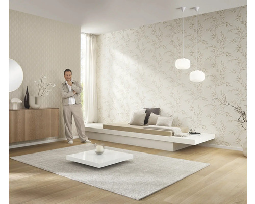 Ljust vardagsrum med mönstrade tapeter, låg soffa, matta och dekoration