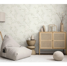 Ljust vardagsrum med blad-tapet, sittsäck, byrå och sidobord