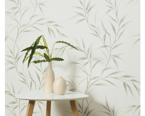 Dekorativ tapet med bladmönster, kombinerat med ett bord och krukväxter i vaser.