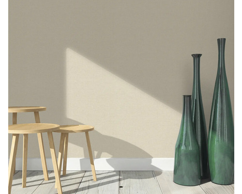 Scen med tre träpallar och tre smala dekorativa vaser på ett trägolv framför en vägg