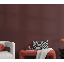 Vardagsrum med sittbänk, kuddar och dekoration framför en vägg