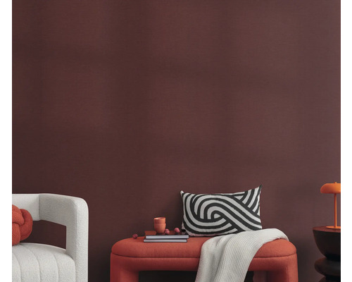 Vardagsrum med sittbänk, kuddar och dekoration framför en vägg