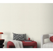 Vardagsrum med bänk, kudde och dekoration framför en ljus vägg