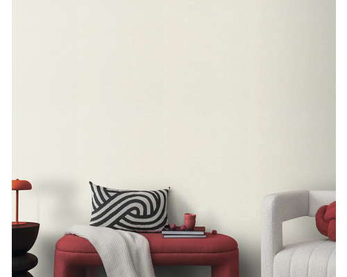 Vardagsrum med bänk, kudde och dekoration framför en ljus vägg