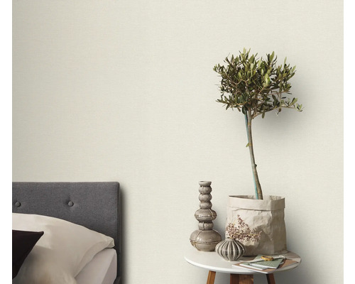 Sovrum med säng, sidobord och dekorativa element som en växt och vaser