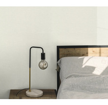 Sovrumsscen med sänglampa på träbord bredvid säng