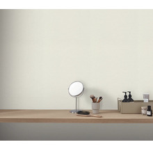 Dekorativa kosmetiska artiklar på ett sminkbord framför en vägg