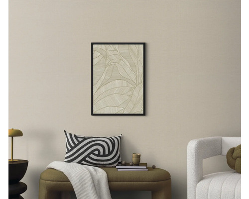Vardagsrum med en inramad bild av ett bladmönster