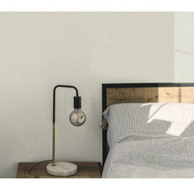 Sovrum med sänglampa och mönstrad tapet