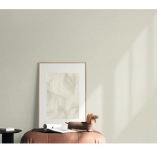 Dekorativt vardagsrum med mönstrad tapet, inramad bild och dekorativ figur