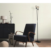 Vardagsrum med fåtölj, golvlampa och byrå för en stilfull atmosfär