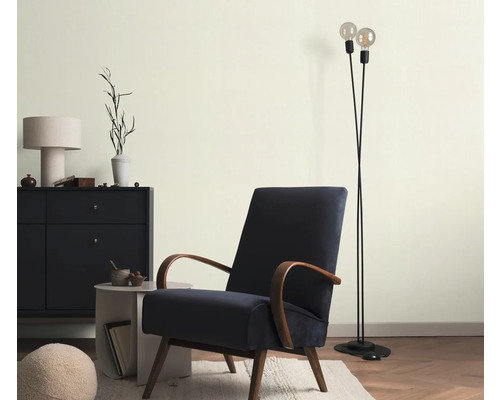 Vardagsrum med fåtölj, golvlampa och byrå för en stilfull atmosfär