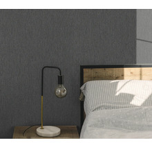 Sovrum med grå strukturtapet, sängbord och lampa.