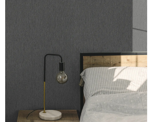 Sovrum med grå strukturtapet, sängbord och lampa.