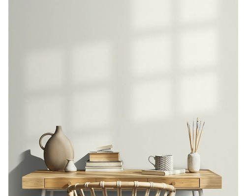 Ljust arbetsrum med skrivbord, bokstapel, vaser och en mugg