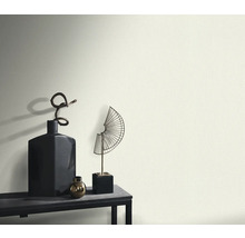 Dekorativa vaser och skulpturer på ett bord framför en vägg